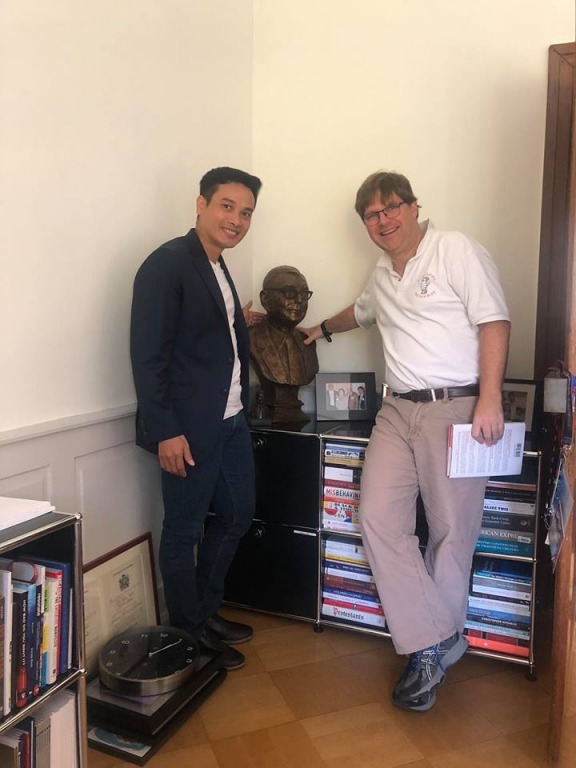 Anh Thái Phạm - Founder Happy.Live chụp hình cùng Guy Spier bên tượng ngài Charlie Munger tại văn phòng của ông ở Thụy Sĩ