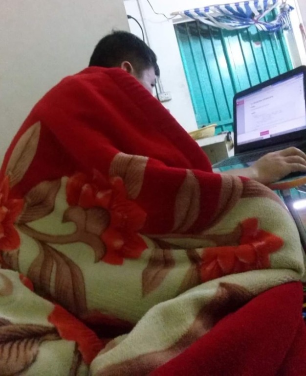 Anh Hiếu trùm chăn làm việc trong nhà trọ ngày chưa mua nhà. 